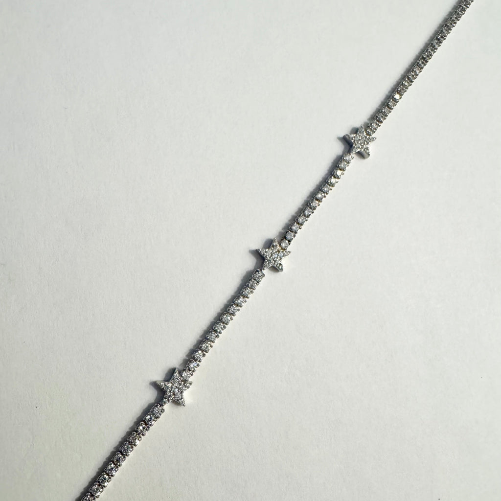 Silver bracelet with small diamonds on a light gray background