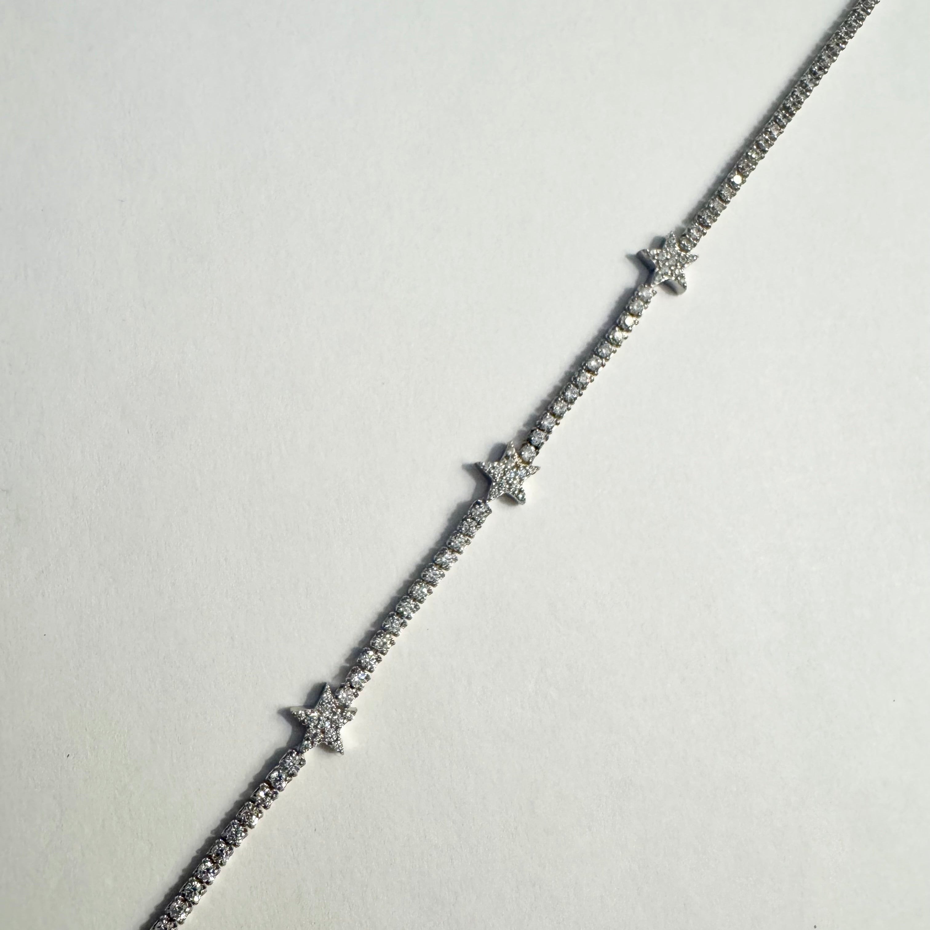 Silver bracelet with small diamonds on a light gray background